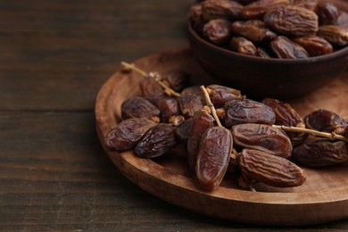 Photo of Tasty dried dates on wooden table, closeup. Space for text