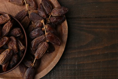 Photo of Tasty dried dates on wooden table, top view. Space for text