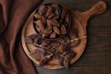 Photo of Tasty dried dates on wooden table, top view