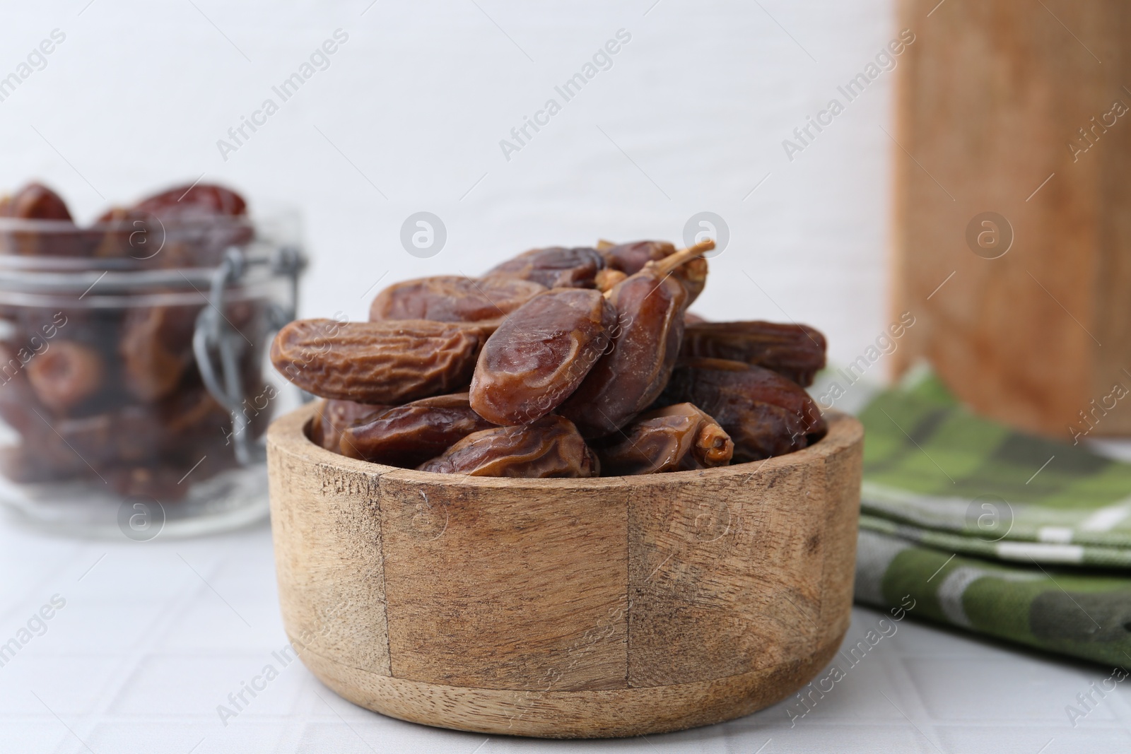 Photo of Tasty dried dates on white tiled table, closeup