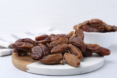 Photo of Tasty dried dates on light table, closeup