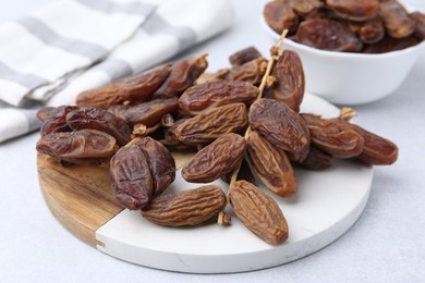 Photo of Tasty dried dates on light table, closeup