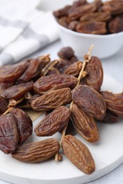 Photo of Tasty dried dates on light table, closeup