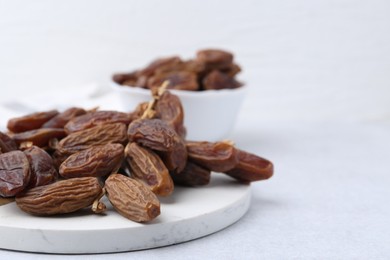 Photo of Tasty dried dates on light table, closeup. Space for text