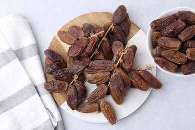 Photo of Tasty dried dates on light table, top view