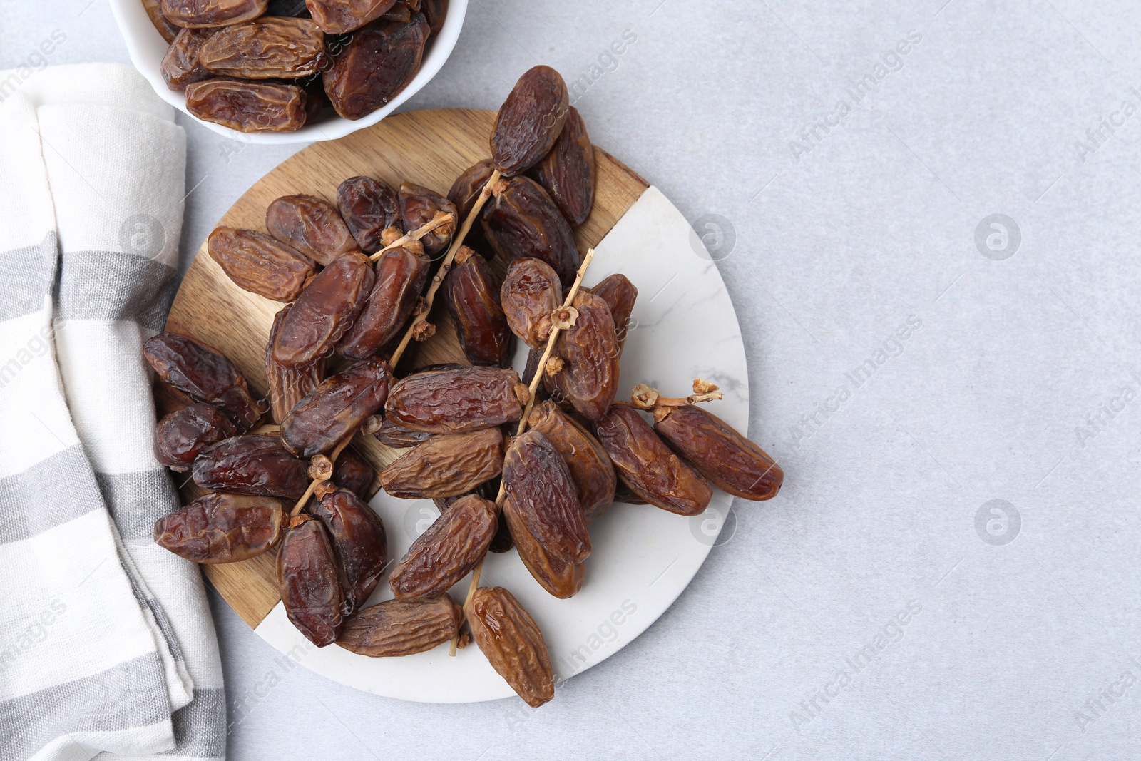 Photo of Tasty dried dates on light table, top view