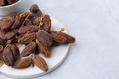 Photo of Tasty dried dates on light table, closeup. Space for text