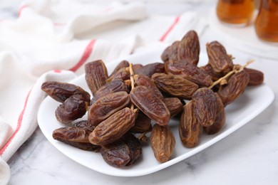 Photo of Tasty dried dates on white marble table