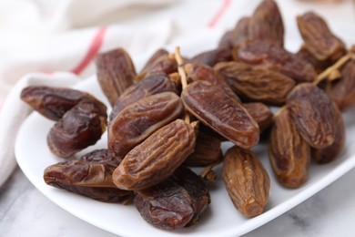 Photo of Tasty dried dates on white marble table