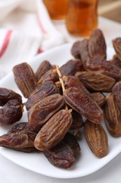 Photo of Tasty dried dates on white table, closeup