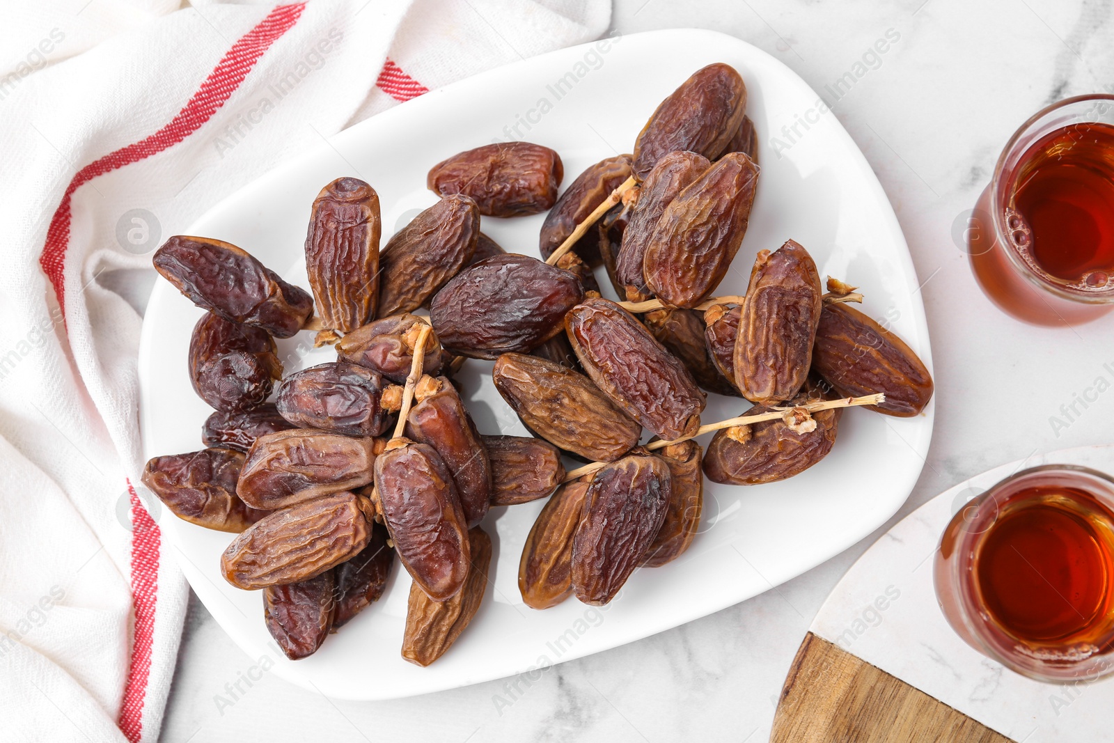 Photo of Tasty dried dates and tea on white marble table, flat lay