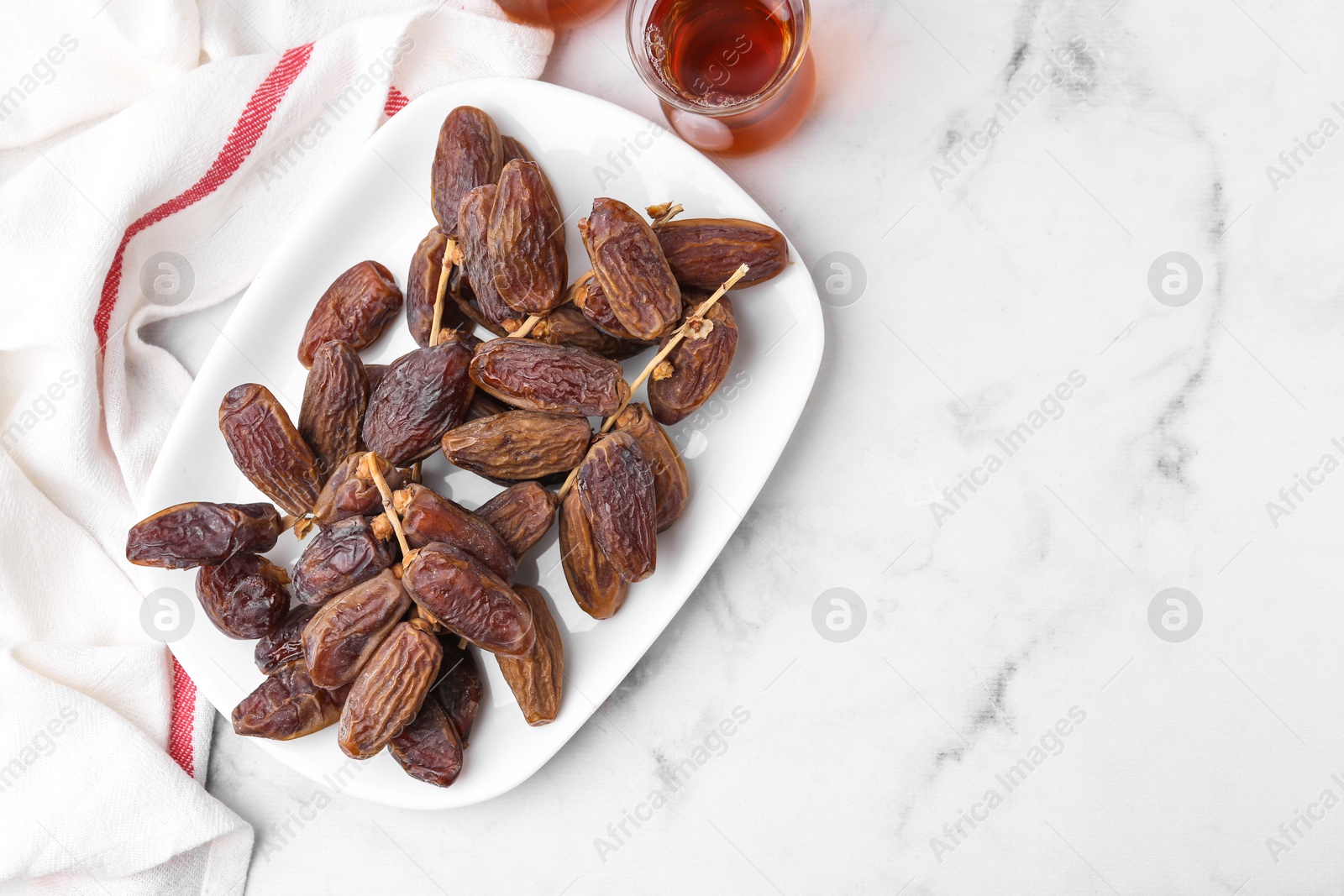 Photo of Tasty dried dates and tea on white marble table, flat lay. Space for text