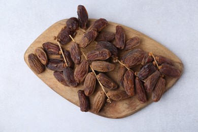 Photo of Tasty dried dates on light table, top view