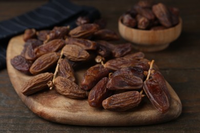 Photo of Tasty dried dates on wooden table, closeup