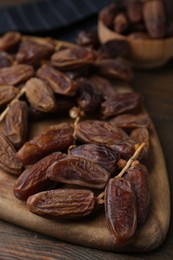 Photo of Tasty dried dates on wooden table, closeup