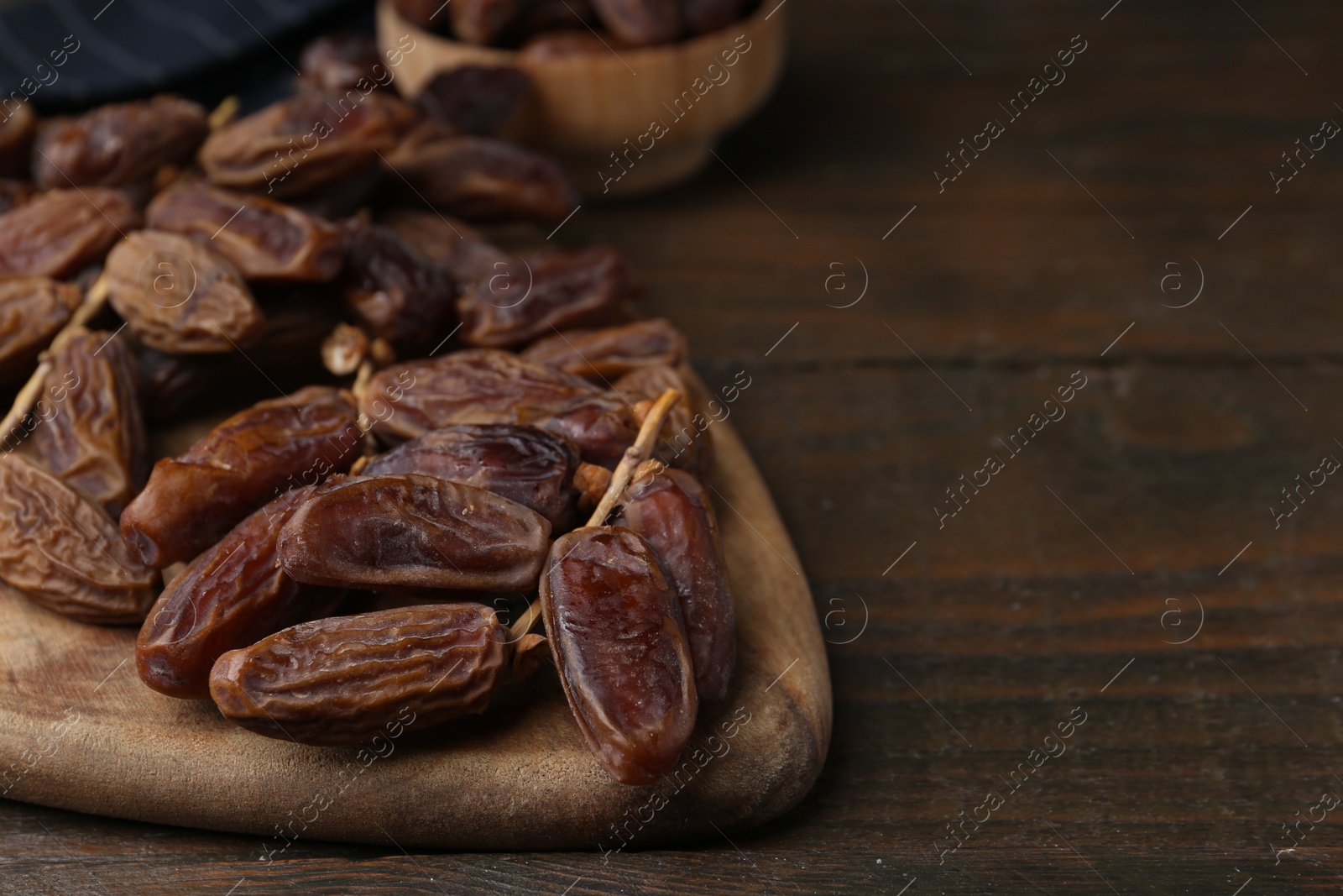 Photo of Tasty dried dates on wooden table, closeup. Space for text