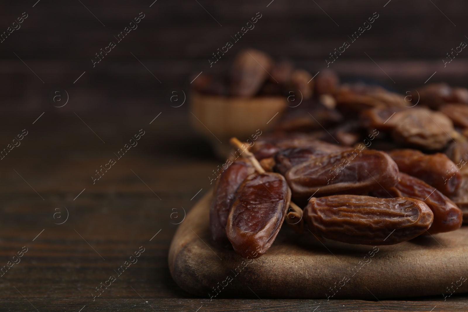 Photo of Tasty dried dates on wooden table, closeup. Space for text