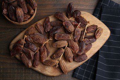 Photo of Tasty dried dates on wooden table, top view