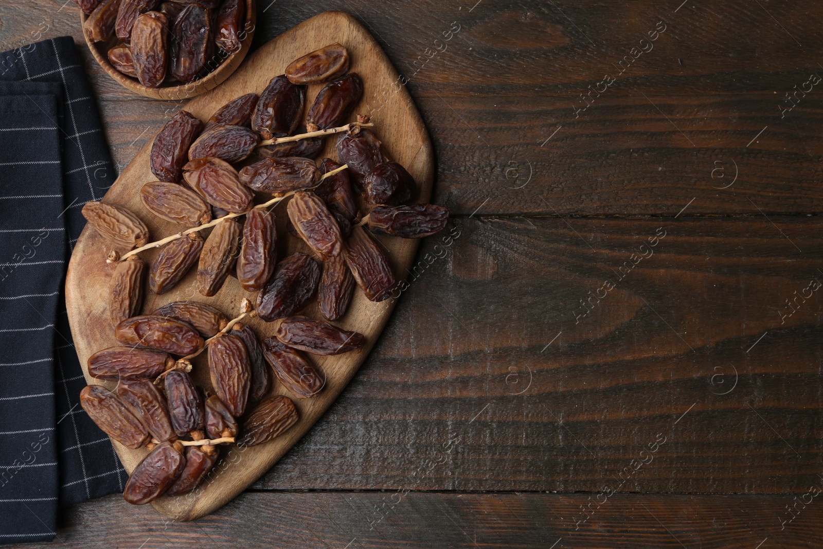 Photo of Tasty dried dates on wooden table, top view. Space for text