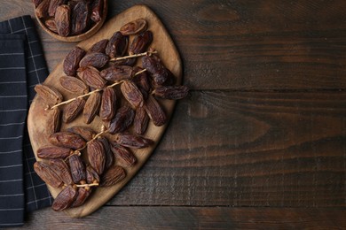 Photo of Tasty dried dates on wooden table, top view. Space for text