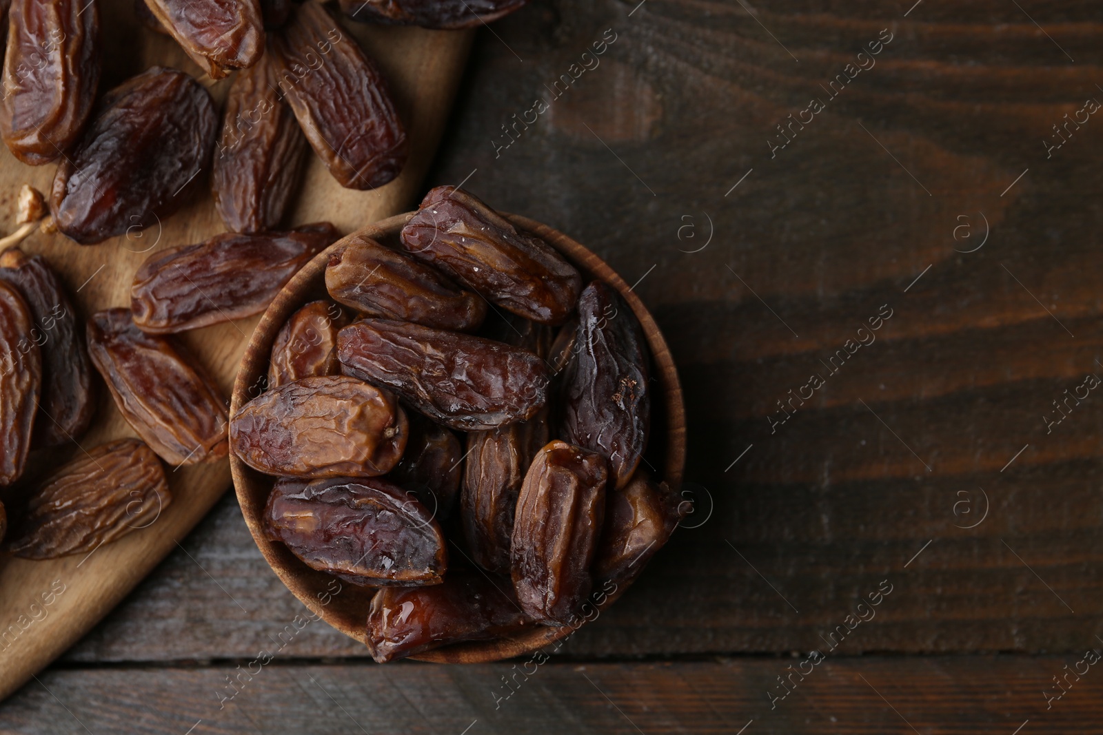 Photo of Tasty dried dates on wooden table, top view. Space for text