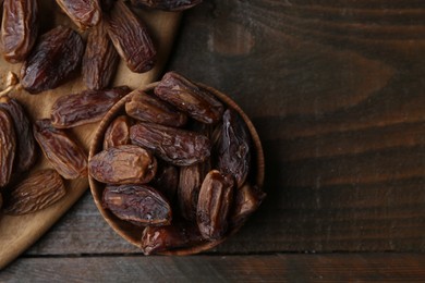 Photo of Tasty dried dates on wooden table, top view. Space for text