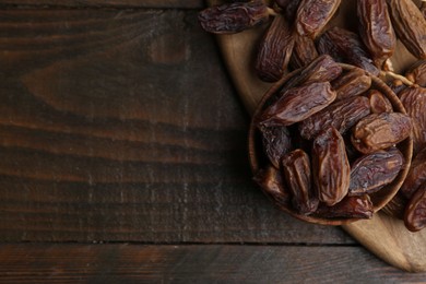 Photo of Tasty dried dates on wooden table, top view. Space for text