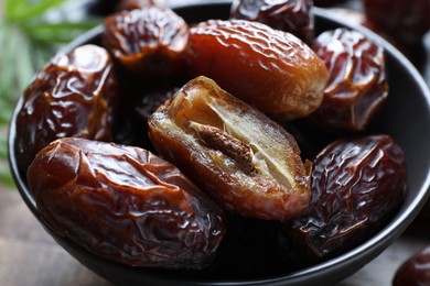 Photo of Tasty dried dates in bowl on table, closeup