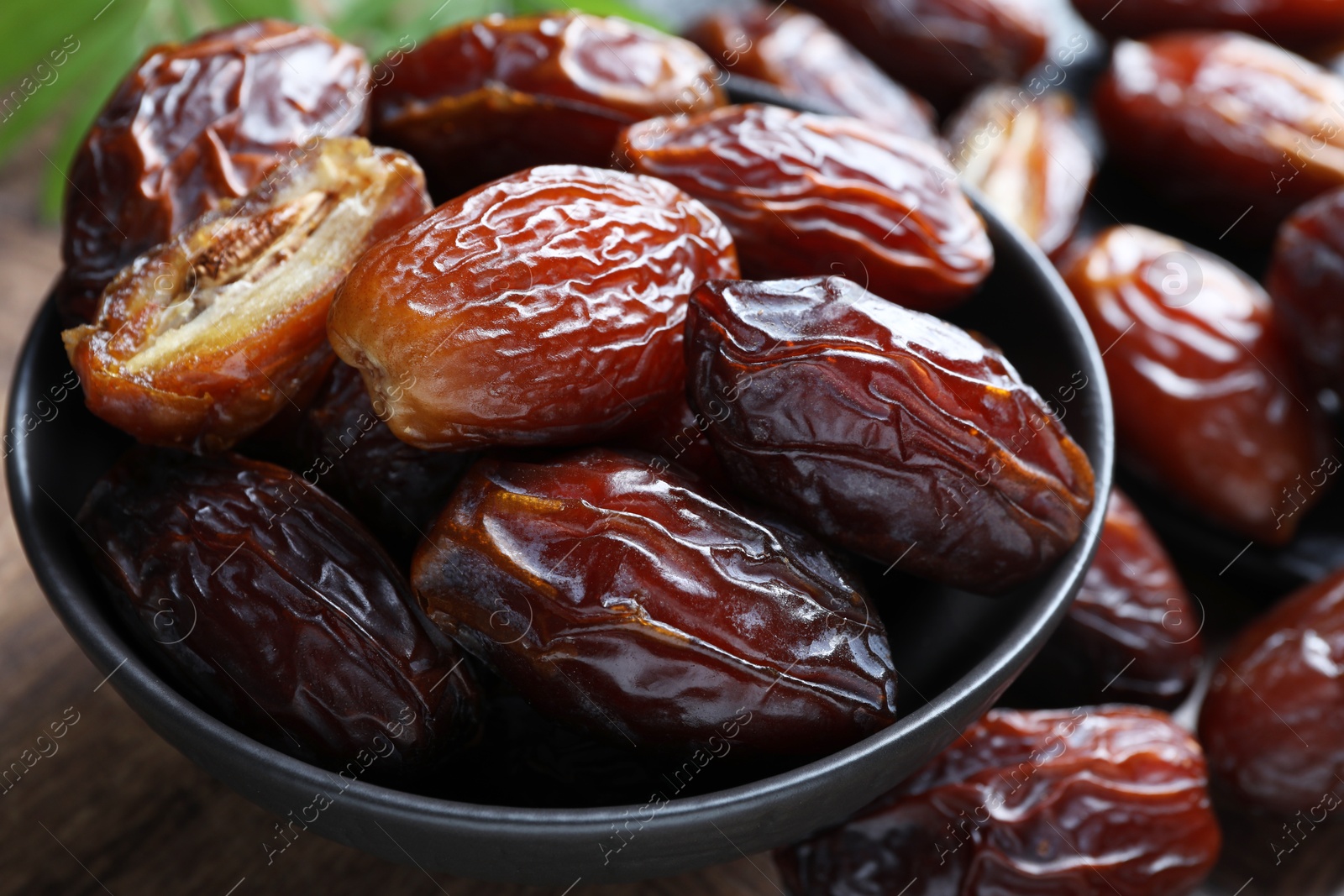 Photo of Tasty dried dates in bowl on table, closeup