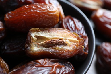 Photo of Many tasty dried dates in bowl, closeup