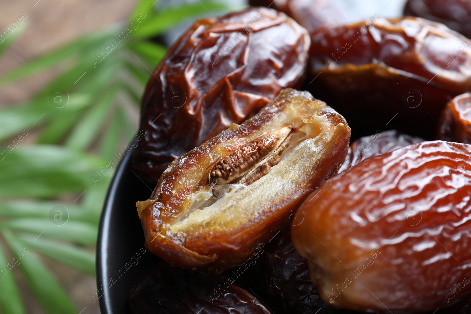 Photo of Tasty dried dates in bowl on table, closeup