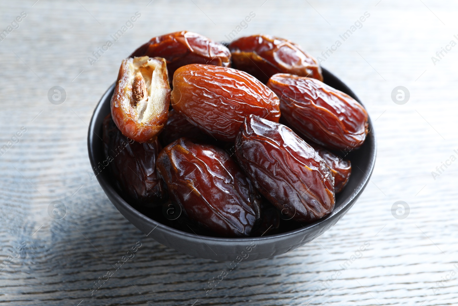 Photo of Tasty dried dates on light wooden table, closeup