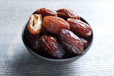 Photo of Tasty dried dates on light wooden table, closeup