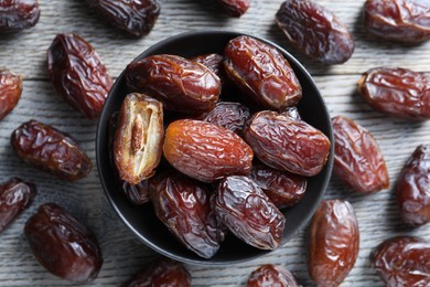 Photo of Tasty dried dates on light wooden table, flat lay