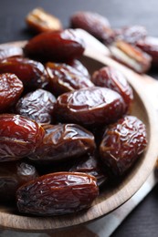 Photo of Tasty dried dates on black table, closeup