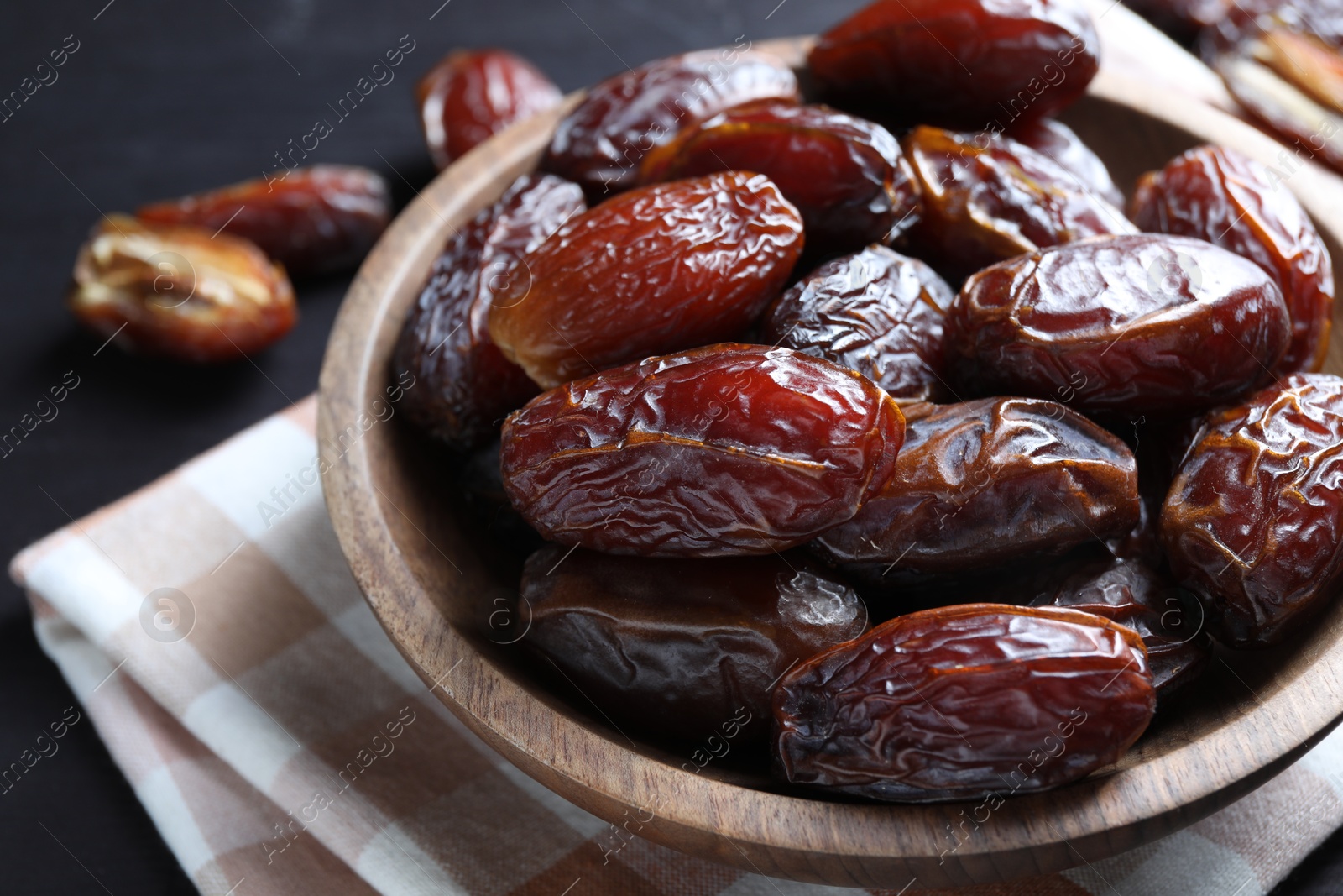 Photo of Tasty dried dates on black table, closeup