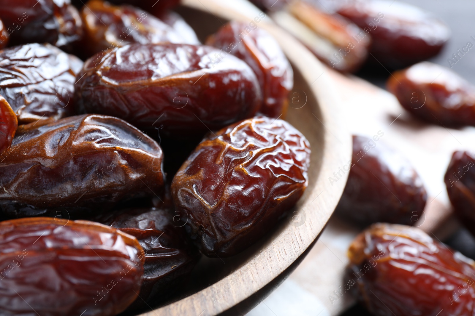 Photo of Many tasty dried dates in bowl on table, closeup