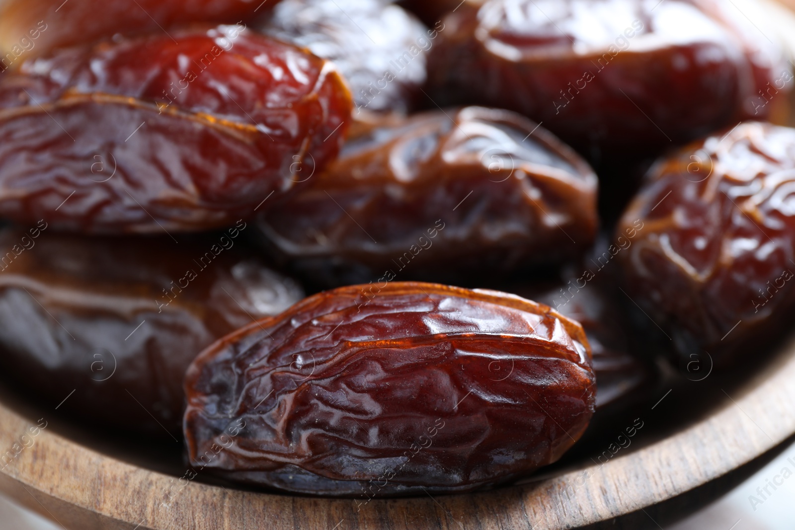 Photo of Many tasty dried dates in bowl, closeup