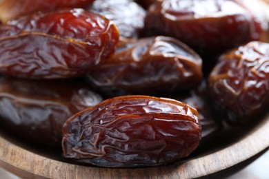 Photo of Many tasty dried dates in bowl, closeup