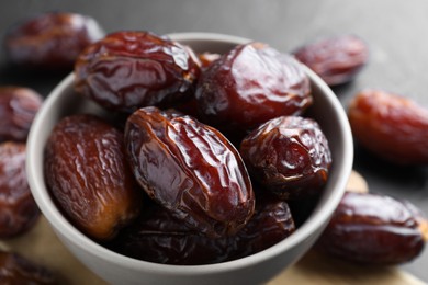 Photo of Tasty dried dates in bowl on table, closeup