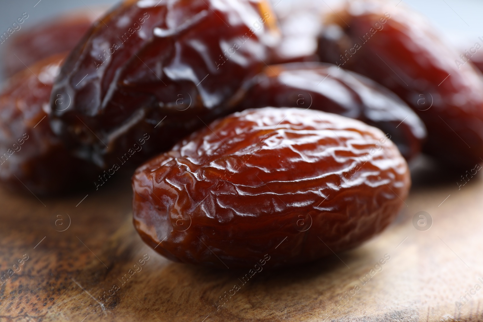 Photo of Tasty dried dates on wooden board, closeup