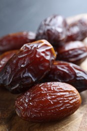 Photo of Tasty dried dates on wooden board, closeup