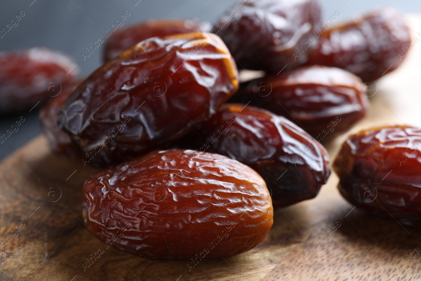 Photo of Tasty dried dates on wooden board, closeup