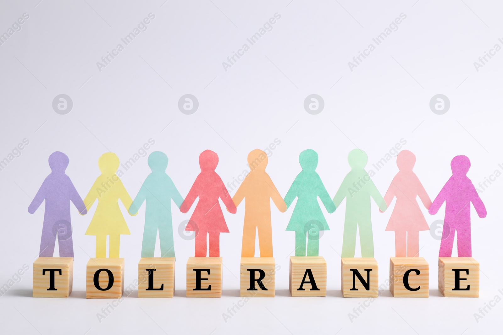 Image of Wooden cubes with word Tolerance and paper human figures on white background