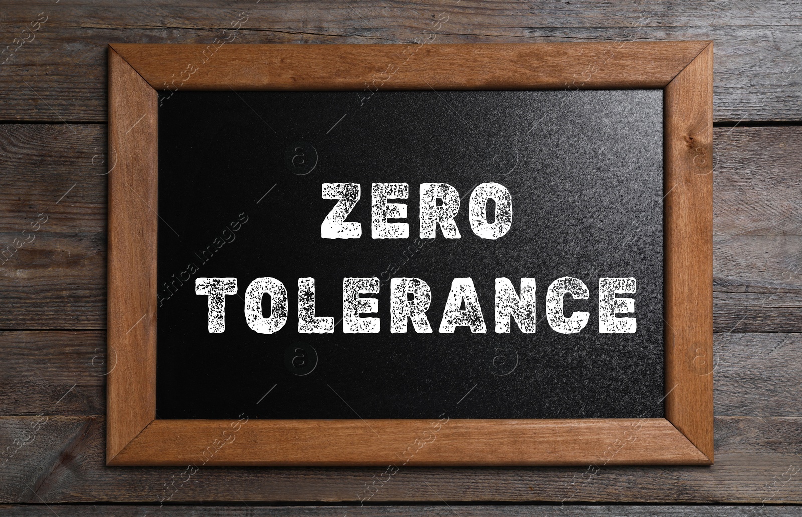 Image of Zero Tolerance concept. Small chalkboard with words on wooden background