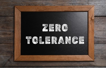 Image of Zero Tolerance concept. Small chalkboard with words on wooden background