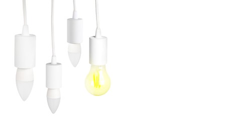 Image of One glowing light bulb among others on white background. Banner design with space for text