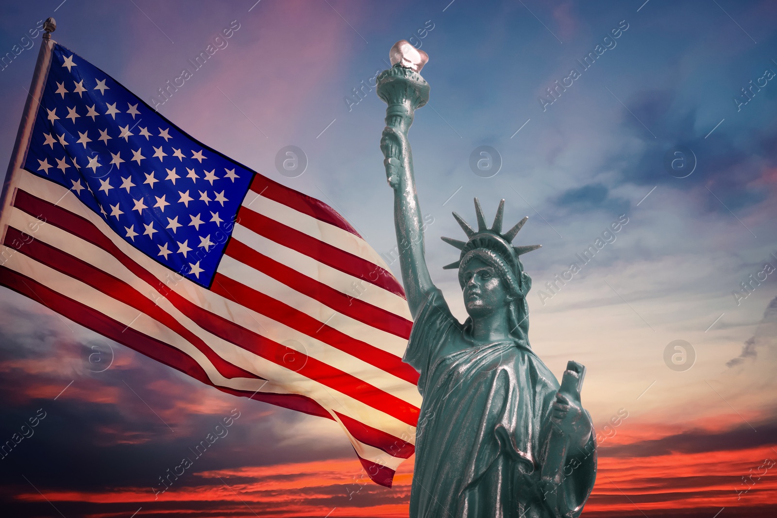 Image of Statue of Liberty and American flag against sunset sky