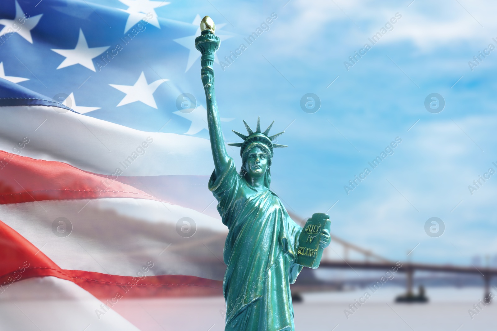 Image of Statue of Liberty against American flag and bridge