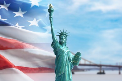 Image of Statue of Liberty against American flag and bridge